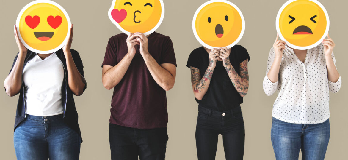 Diverse people holding emoticon